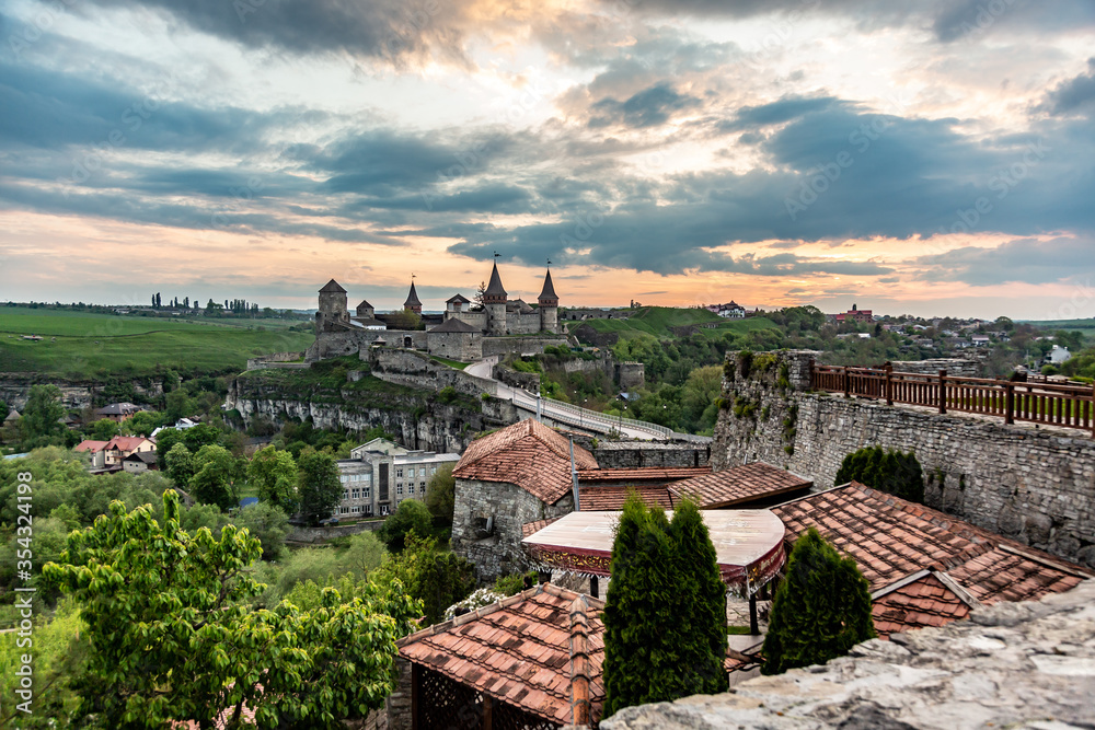 View of Kamianets-Podilskyi Castle and nearby buildings at sunset, Ukraine. Horizontal orientation. 