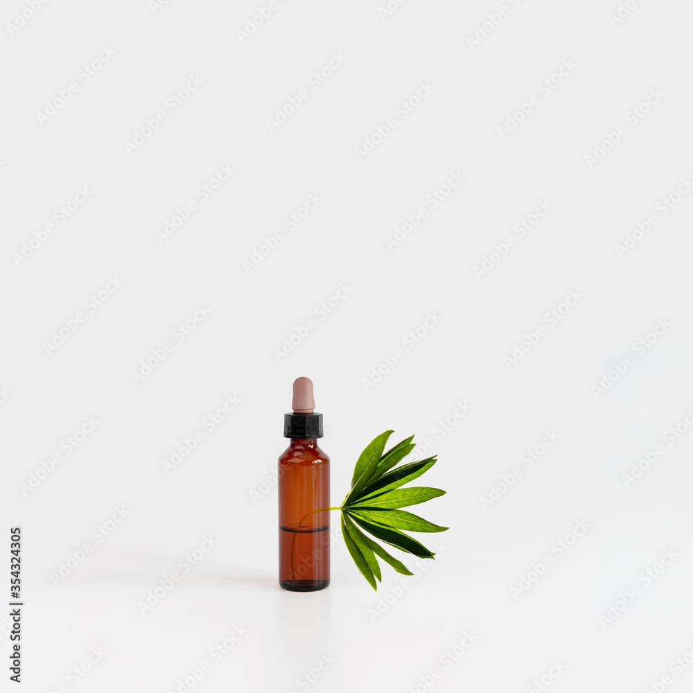 Natural cosmetic bottle on gray background with green plant. New normal concept. Balancing composition from figures. Natural, beauty body health cosmetic products. Natural cosmetic bottle on gray background with green plant. New normal concept. Balancing composition from figures. Natural, beauty body health cosmetic products.