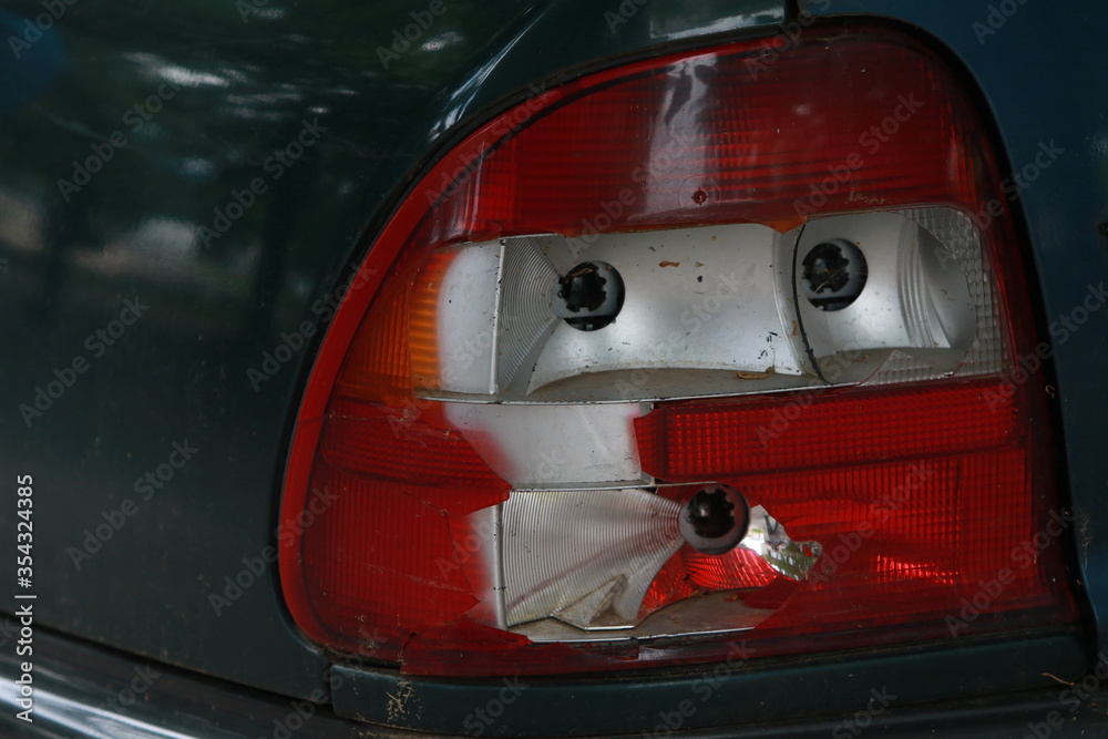 Fototapeta premium Abandoned car with broken windshield and side windows, flat tires and broken headlights