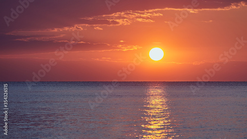 Fototapeta Naklejka Na Ścianę i Meble -  Beautiful red pink orange dawn on the sea without waves.