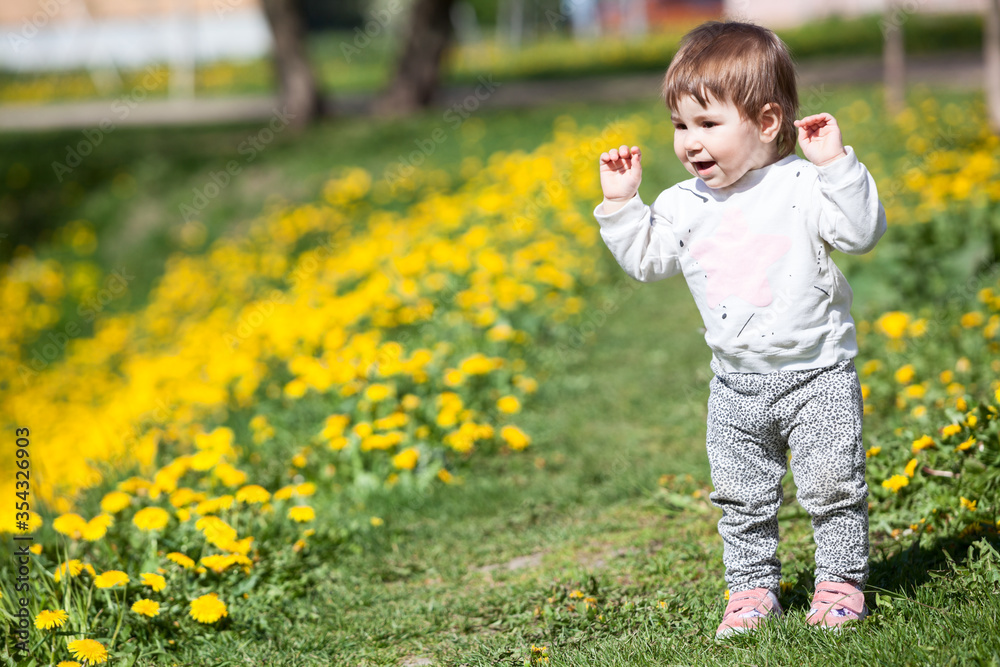 Happy laughing little child with hands up, walking and rejoicing to step his legs himself Happy laughing little child with hands up, walking and rejoicing to step his legs himself