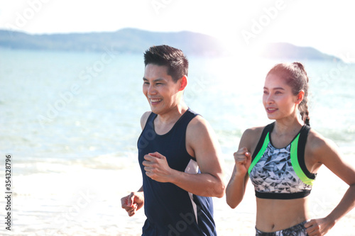 Young runner jogging outdoor on summer tropical island beach with blue sea, doing exercise outdoor, sport guy jogger athlete doing and training workout outdoor
