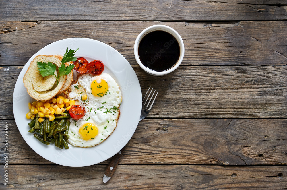 Fried eggs with tomatoes, green beans, corn and toast. English vegetarian breakfast. Top view. Coffee and fried eggs on a wooden tray. Wood background. Free space for text. Fried eggs with tomatoes, green beans, corn and toast. English vegetarian breakfast. Top view. Coffee and fried eggs on a wooden tray. Wood background. Free space for text.