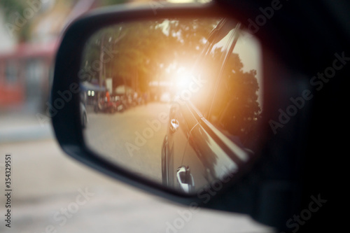 Abstract wing mirror view of car. Looking back traveling in a rural area with bike beside road. © thongchainak
