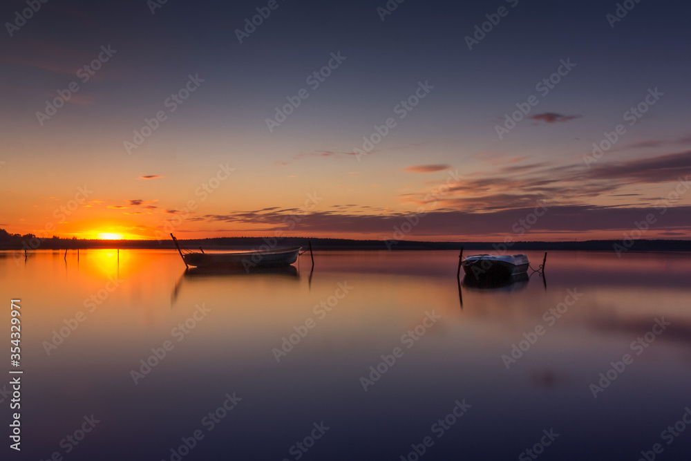 Parking for small fishing boats on the lake during sunset. Beautiful background for cards