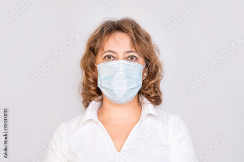 Portrait of a woman adult elderly in a medical mask on an isolated background