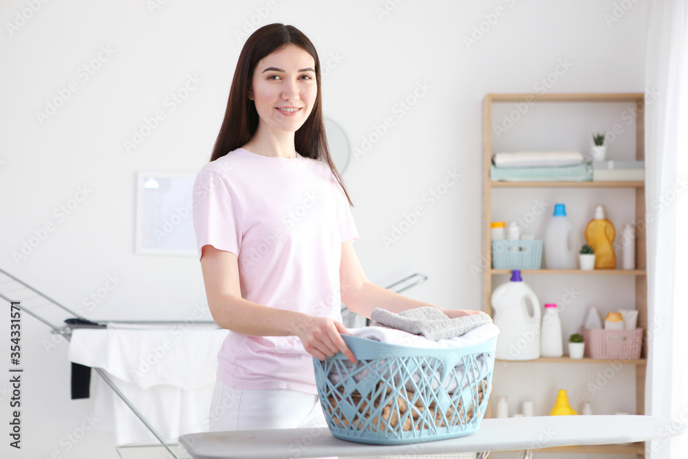 Young housewife in the laundry room. Laundry, household chores
Young housewife in the laundry room. Laundry, household chores