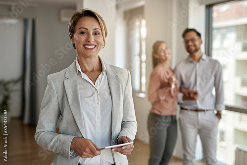 Portrait of happy female real estate agent. photo