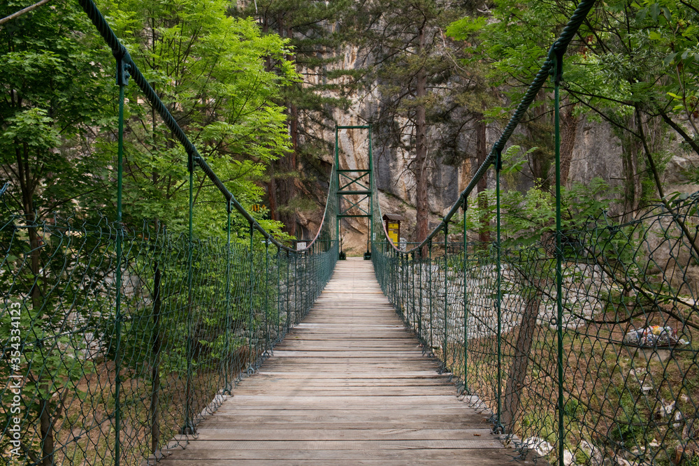Old wooden hanging bridge upon the mountain leading from the Lazar cave in Lazarev canyon, Serbia