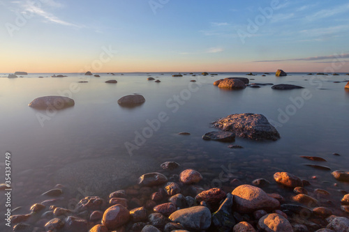 Baltic sea coast with stones and a beautiful sunset  long exposure photograph as a background for a postcard