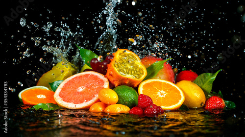 Freeze Motion Shot of Fresh Fruits with Splashing Water Isolated on Black Background. © Lukas Gojda