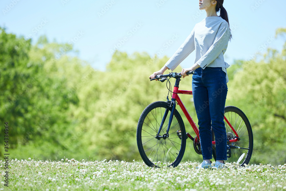 休日にサイクリングを楽しむ若い女性