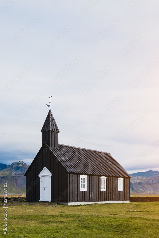 Black church in the meadow and field in Iceland. Icelandic scenic travel destination of religion.