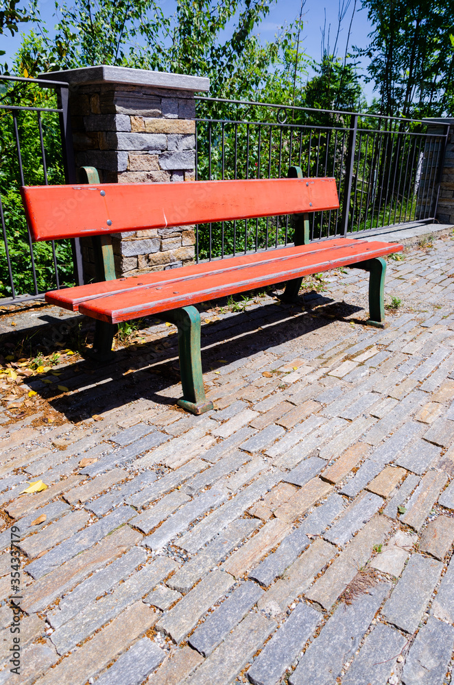 Red bench on cobblestone