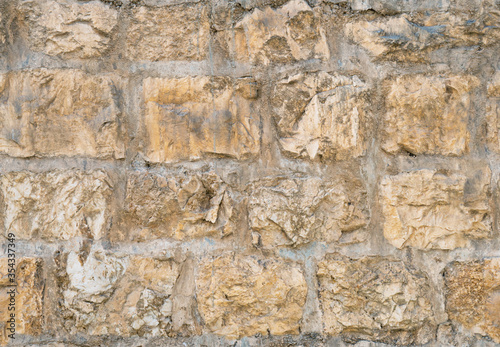 Medieval ancient stone wall in old Jerusalem seamless texture background.