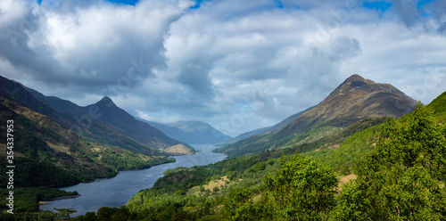 a view over loch leven from the west highland way near kinlochleven and fort william in the argyll region of the highlands of scotland during a warm spring day showing green forest and hillsides