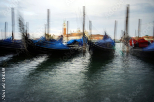 Venice, Italy - August 25, 2018. Gondolas at the pier overlooking the San Giorgio Maggiore. Gondolas at the pier in Venice.