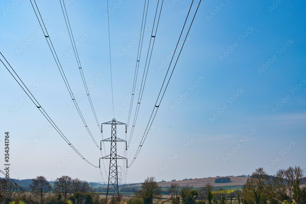 high voltage power lines receding towards a pylon.