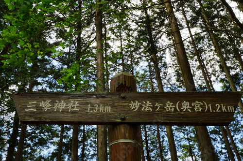 The road sign near Mitsumine Jinja Shrine Okumiya at Myohogatake mountain in Chichibu, Tokyo, Japan. Japanese text:Right"Myohogatake mountain (Okumiya((Rear shrine))) ". Left:"Mitsumine Jinja Shrine