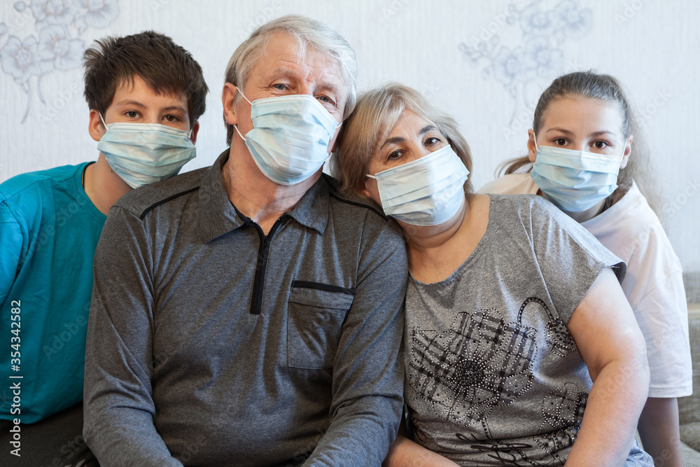 Family wearing protective medical masks for prevent virus, parents with preteen children portrait