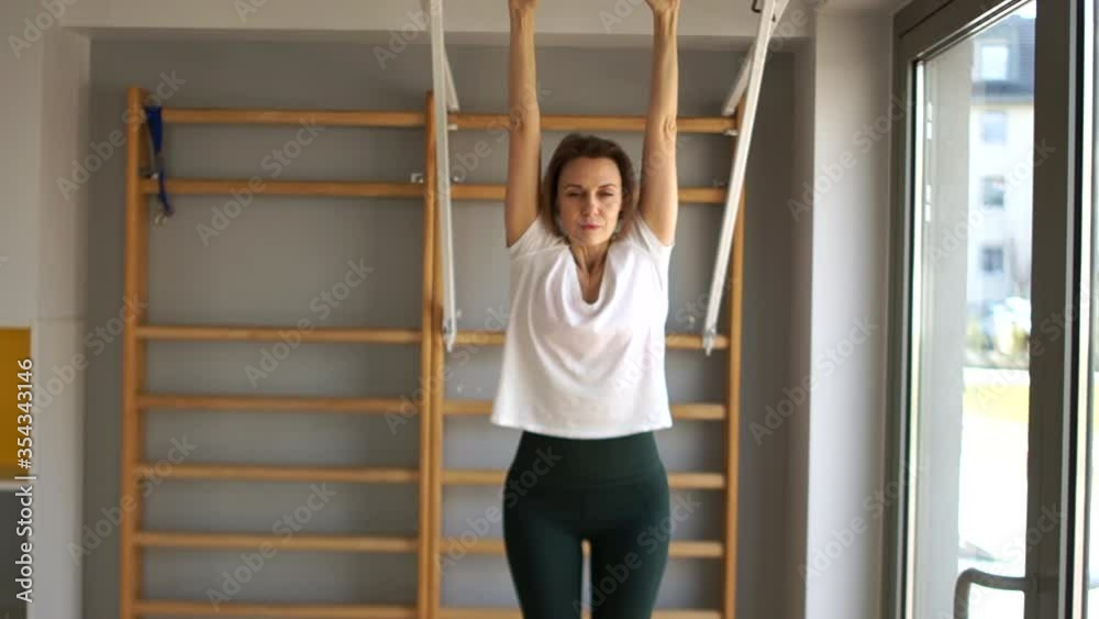 Girl performs press exercises on the horizontal bar, raising her legs forward. Gym Sports Quarantine Girl performs press exercises on the horizontal bar, raising her legs forward. Gym Sports Quarantine