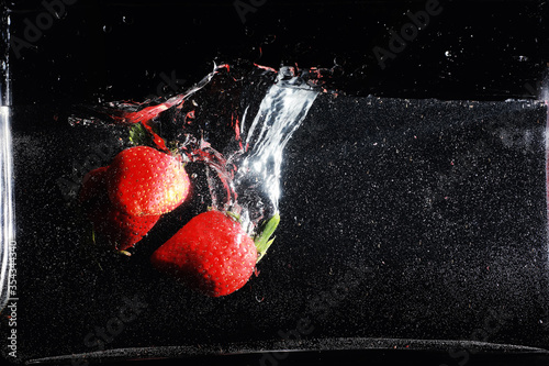 Water drops on ripe sweet strawberry. Fresh berry background with copy space for your text. Vegan food concept.