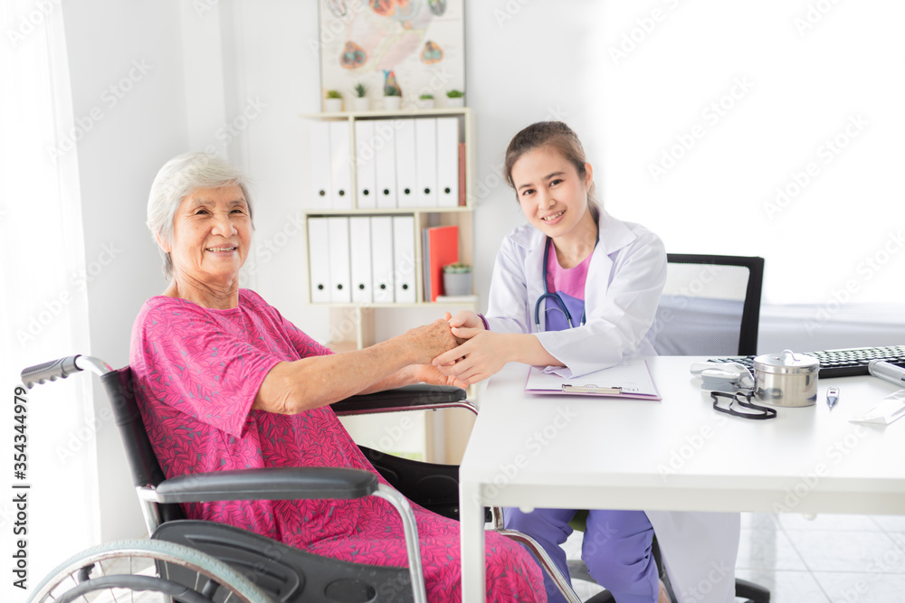 Fototapeta premium Asian doctor talk with old female patient about disease symptom, they holding hand together, elderly health check up, happiness hospital, hand in hand