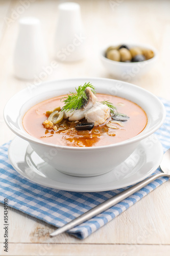 Fish soup with vegetables lemon and olives.