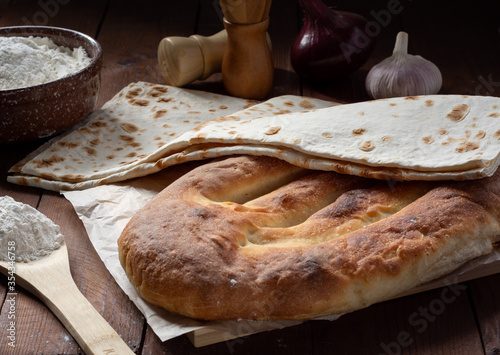 Armenian national bread matnakash and thin lavash on a wooden table photo