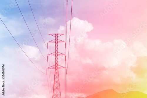 Cotton candy & puffy fluffy white clouds & cumulus cloudscape on Gradient yellow pink & blue sky background with high voltage electricity tower in tropical summer or spring sunlight & sun rays   
