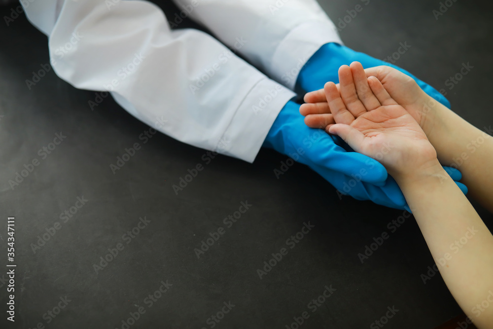 Medical concept. The doctor in gloves holds the patient's hand. The moral help of the doctor to his patients. Cardiologist consultation. Epidemic.