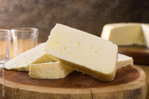 Slices of semi cured Brazilian Canastra chesse in wood background