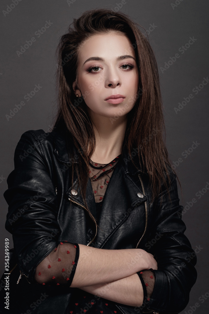 fashion model woman in a black jacket on a gray background