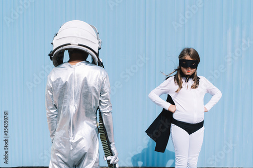 Two kids in astronaut and superhero costumes photo