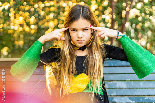 Girl posing in super heroine costume on a bench photo