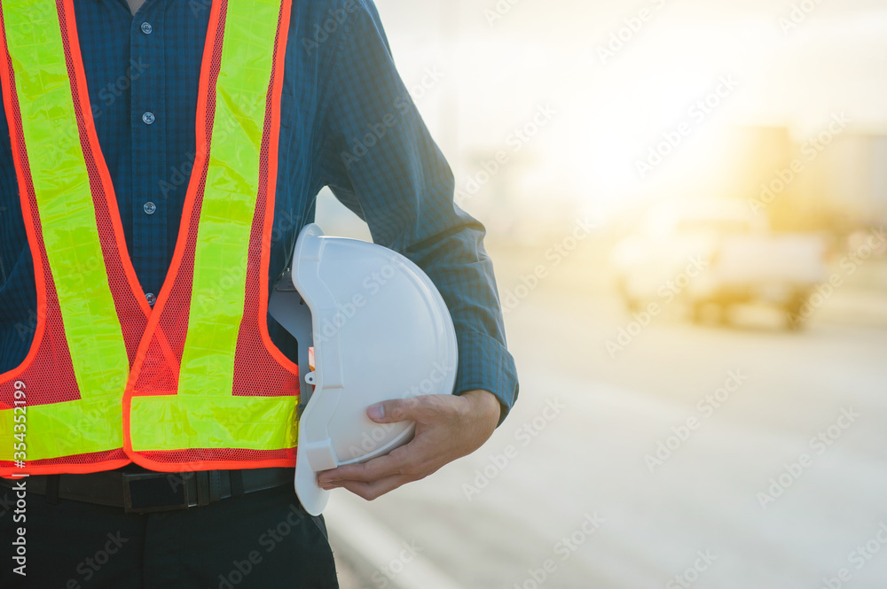 Close up hand holding white helmet hard hat Engineering concept,Technician holding white hat safety hard hat sunlight background