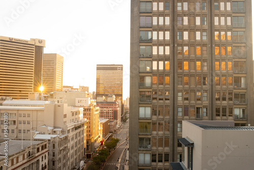 Sunset over buildings in city center Cape Town South Africa with reflections of table mountain in window