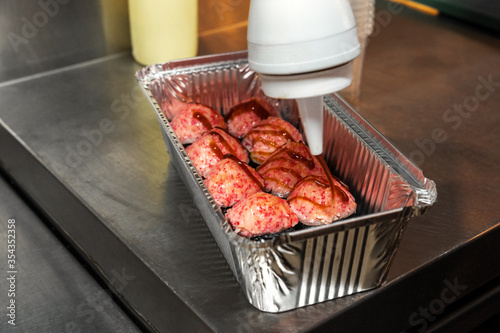 Rolls with mayonnaise caps are Packed in an aluminum box and poured with sauce photo