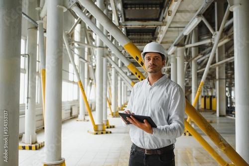 happy male industrial technician inside a factory