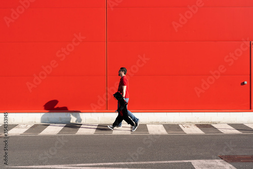 Man walking with his little girl wearing black fancy dress on zebra crossing