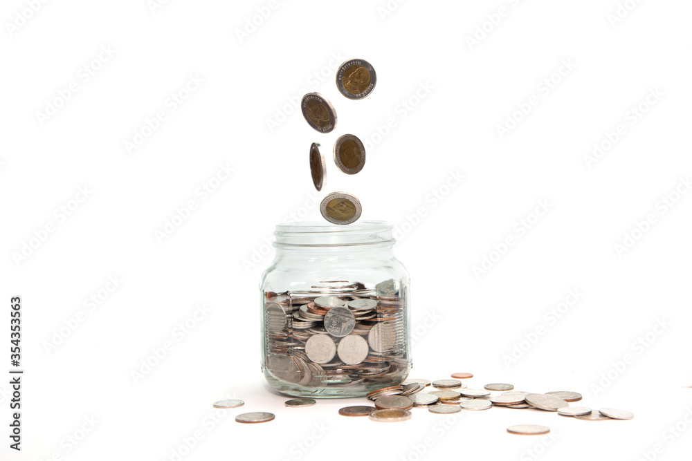 coins dropping into the glass for saving the money. coins dropping into the glass for saving the money.