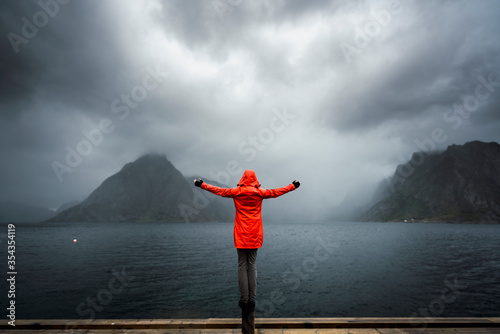 Norway, Lofoten, rear view of man balancing on a pole at the coast photo