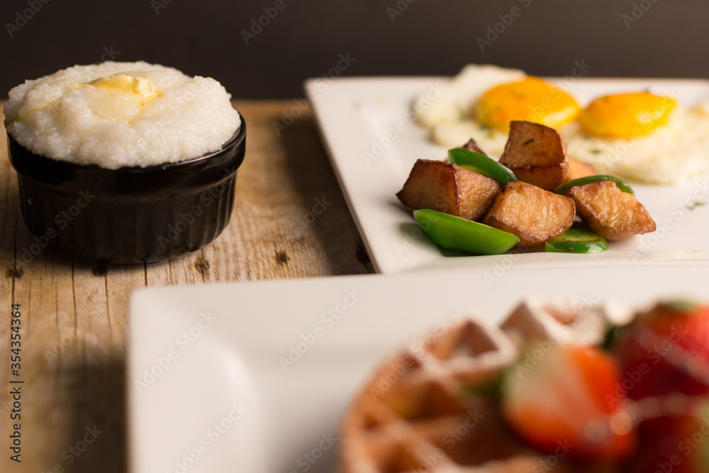 Breakfast Belgium waffle side of eggs potato grits and cappuccino coffee Breakfast Belgium waffle side of eggs potato grits and cappuccino coffee