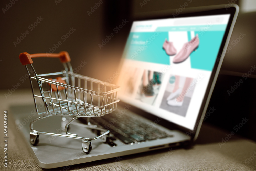 Trolley shopping cart on a laptop keyboard. Ideas for shopping online or e-commerce from internet.