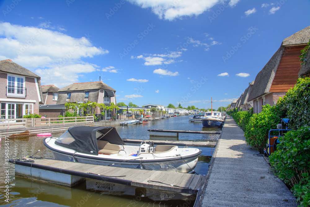 Naklejka premium Canal with holiday homes and boats in Scheendijk, Netherlands