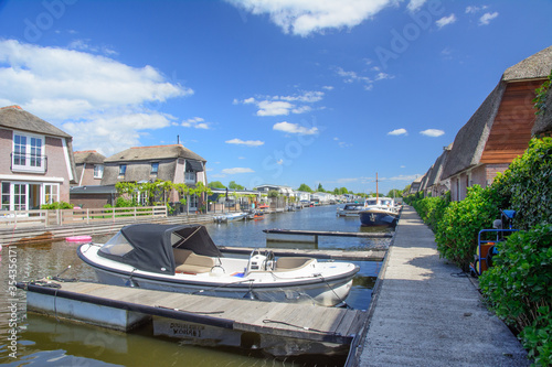 Canal with holiday homes and boats in Scheendijk, Netherlands