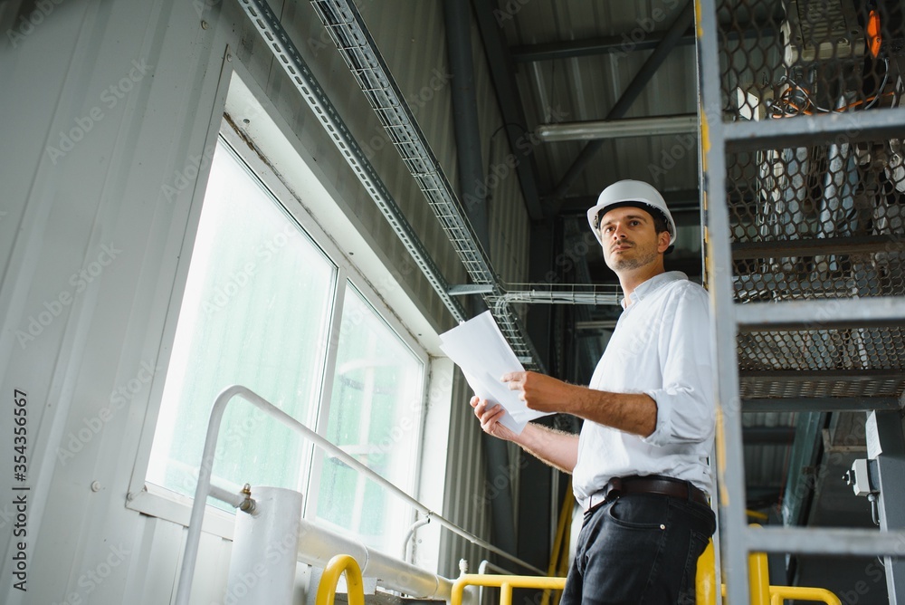 happy male industrial technician inside a factory happy male industrial technician inside a factory
