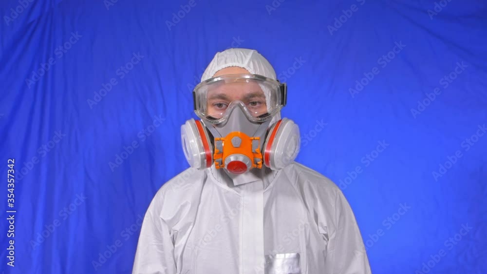 Scientist virologist in respirator. Slow motion. Man close up portrait, wearing protect medical aerosol spray paint mask. Concept health safety N1H1 virus protection coronavirus epidemic 2019 nCoV. Scientist virologist in respirator. Slow motion. Man close up portrait, wearing protect medical aerosol spray paint mask. Concept health safety N1H1 virus protection coronavirus epidemic 2019 nCoV.
