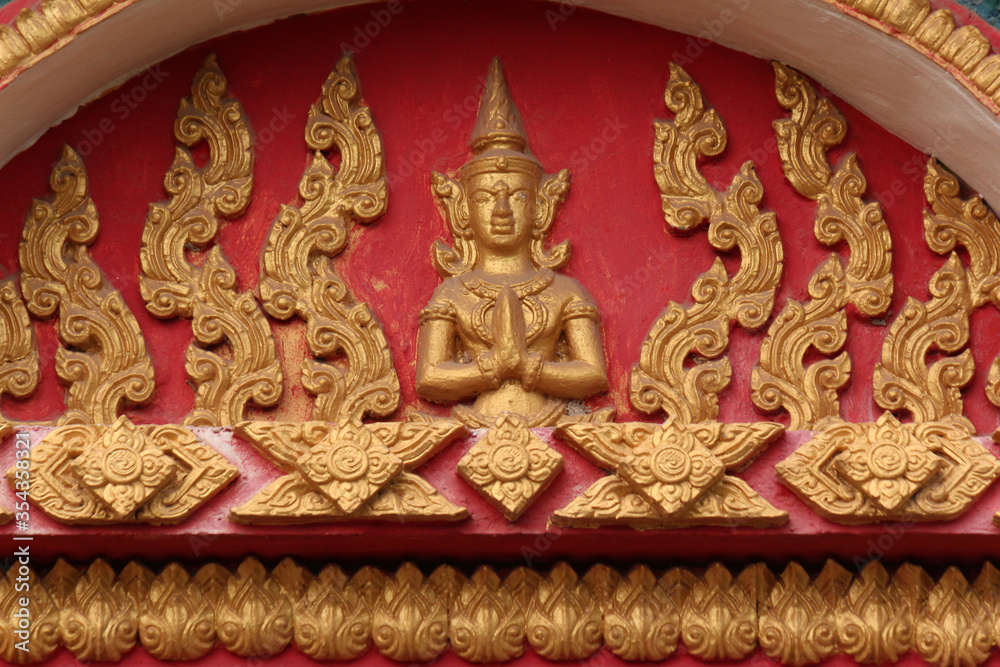 Praying Siamese buddha image in a temple site in Lao PDR, Southeast Asia
