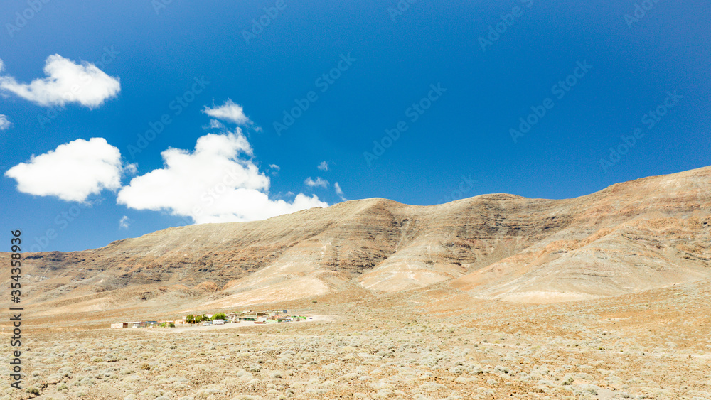 Panorama-Aufnahme einer Wüstenlandschaft mit einer einsamen Siedlung, fotografiert mit einer Kameradrohne